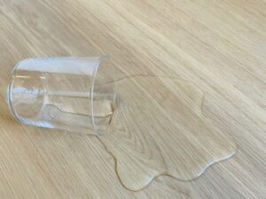 suelo con un vaso de agua derramado